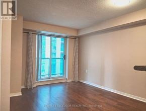 Toronto (Willowdale East) condo for rent - A room with a large window and wooden flooring.