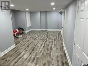Brampton (Sandringham-Wellington) townhouse for rent - A room with wooden flooring and white walls, with a realtor logo in the corner.