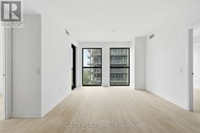 Toronto (Thorncliffe Park) condo for rent - A real estate listing image of a large, empty room with a view of a building outside through the windows.