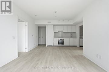 Toronto (Thorncliffe Park) condo for rent - A spacious kitchen with white cabinets and a wooden floor.