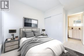 Toronto (Waterfront Communities) condo for rent - A bedroom with a large bed, nightstand, and a mirror on the wall.