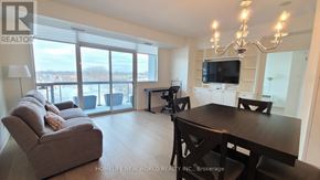 Mississauga (Port Credit) condo for rent - A living room with a couch, a table, and a chandelier.
