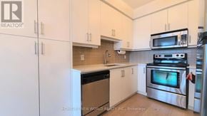 Mississauga (Port Credit) condo for rent - A kitchen with white cabinets and stainless steel appliances.