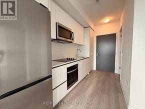 Toronto (Newtonbrook West) condo for rent - A modern kitchen with a refrigerator, microwave, and oven.