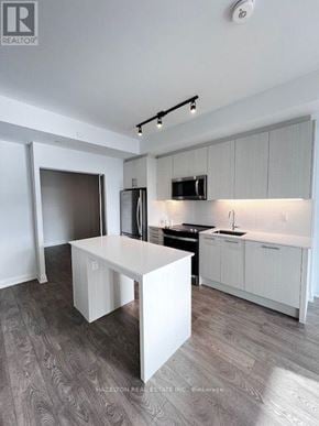 Toronto (East End-Danforth) condo for rent - A modern kitchen with a white island in the middle.