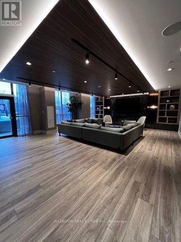 Toronto (East End-Danforth) condo for rent - A modern living room with a grey sofa and wooden flooring.