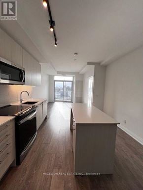 Toronto (East End-Danforth) condo for rent - A modern kitchen with wood flooring and a large island.