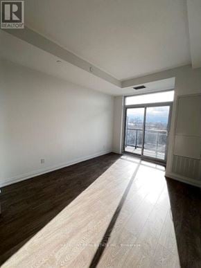 Toronto (East End-Danforth) condo for rent - A large, empty room with a sliding glass door leading to a balcony.
