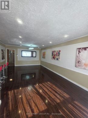 Richmond Hill (Crosby) apartment for rent - A spacious room with wooden floors and a television mounted on the wall.