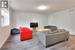 Waterloo townhouse for rent - A living room with a grey sofa, red chair, and a bean bag.