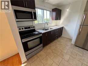 Kitchener apartment for rent - A kitchen with a stove top oven and microwave.