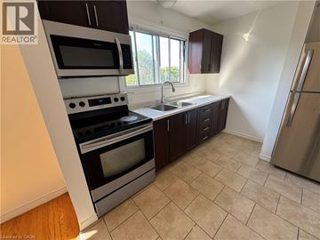 Kitchener apartment for rent - A kitchen with a stove top oven and microwave.
