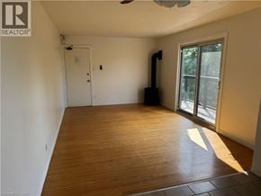 Kitchener apartment for rent - A room with wooden flooring and a sliding glass door.