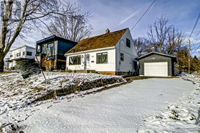 Barrie (Codrington) apartment for rent - A house with a garage is surrounded by snow.