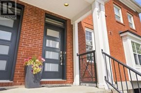 Ottawa townhouse for rent - A house with a black front door and a planter with flowers.