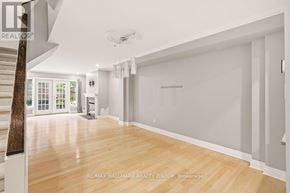 Ottawa townhouse for rent - A spacious room with wooden flooring and white walls.