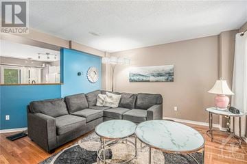 Ottawa townhouse for rent - A living room with a grey couch, a marble table, and a painting on the wall.