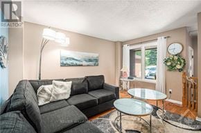 Ottawa townhouse for rent - A living room with a grey couch and a glass table.