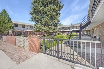 Colorado Springs apartment for rent - A view of a courtyard with a metal fence and a staircase.