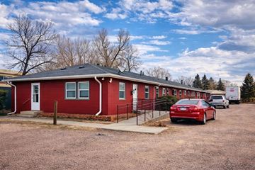 Colorado Springs apartment for rent - A red house with a car parked in front.
