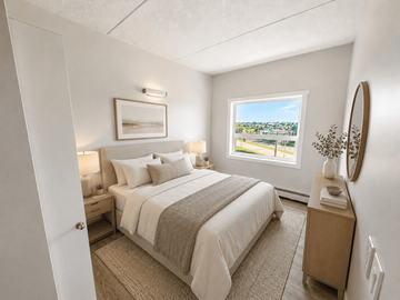 Edmonton apartment for rent - A bedroom with a large bed and a window overlooking a landscape.