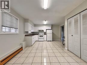 Burnaby apartment for rent - A kitchen with white appliances and a white tile floor.