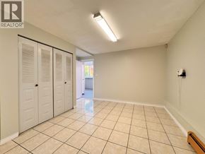 Burnaby apartment for rent - A room with white walls and tiled flooring, with a door on the left and a window on the right.