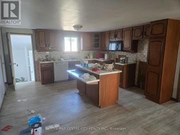 Malahide apartment for rent - A kitchen with wooden cabinets and a countertop with a sink and a window.