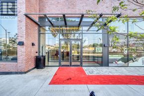 Mississauga (Port Credit) condo for rent - The entrance to a building with a red carpet and glass doors.