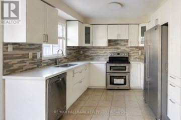 Vaughan (Patterson) apartment for rent - A kitchen with white cabinets and a stone backsplash.