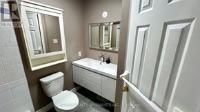 Barrie (Painswick South) apartment for rent - A bathroom with a toilet, sink, and mirror.