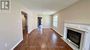 Barrie (Painswick South) apartment for rent - A spacious room with a fireplace and wooden flooring.