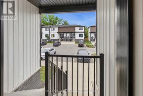 Niagara Falls (Clifton Hill) townhouse for rent - A view from a balcony looking out at a parking lot and a building.