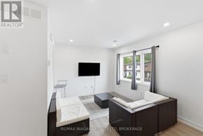 Niagara Falls (Clifton Hill) townhouse for rent - A bedroom with a bed, a chair, and a window.