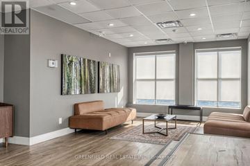 Toronto (Clanton Park) condo for rent - A living room with a brown couch and a painting of trees on the wall.