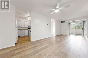 Toronto (Clanton Park) condo for rent - A spacious room with a ceiling fan and wooden flooring.