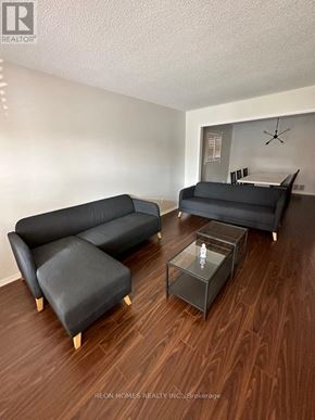 Toronto (Eglinton East) apartment for rent - A living room with a black couch and a glass coffee table.