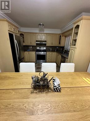 Toronto (Eglinton East) apartment for rent - A kitchen with wooden cabinets and a table with a bowl of utensils on it.