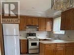 Vaughan (West Woodbridge) apartment for rent - A kitchen with wooden cabinets and a white refrigerator.
