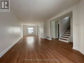 Barrie (Painswick South) apartment for rent - A spacious room with wooden floors and white walls.