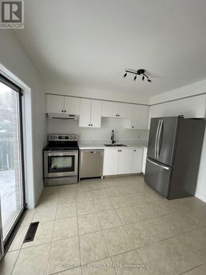 Barrie (Painswick South) apartment for rent - A kitchen with white cabinets and a refrigerator.
