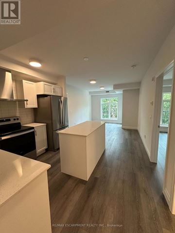 Hamilton (Ancaster) condo for rent - A kitchen with white countertops and a white island in the middle of the room.