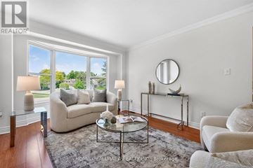 Markham (German Mills) townhouse for rent - A well-lit living room with a glass coffee table and a beige sofa.
