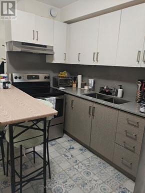 Toronto (Dovercourt-Wallace Emerson-Junction) triplex for rent - A kitchen with a table and chairs in front of a stove.