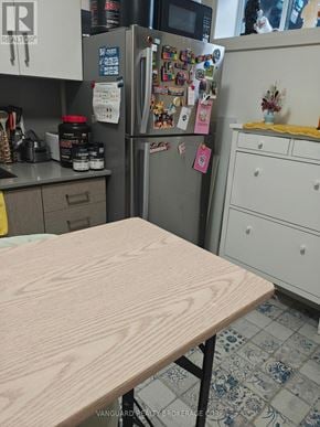 Toronto (Dovercourt-Wallace Emerson-Junction) triplex for rent - A kitchen with a wooden table in the foreground.