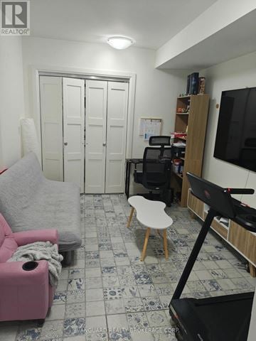 Toronto (Dovercourt-Wallace Emerson-Junction) triplex for rent - A living room with a pink chair and a treadmill.