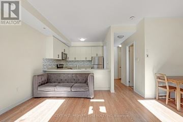Brampton (Bram East) townhouse for rent - A living room with a grey couch and a wooden table.