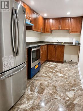 Brampton (Northwest Brampton) apartment for rent - A kitchen with a refrigerator and wooden cabinets.