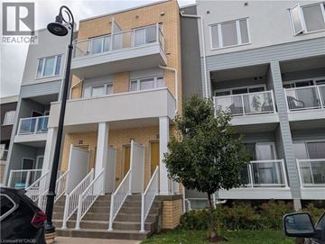 Kitchener townhouse for rent - Apartment building with a tree in front of it.