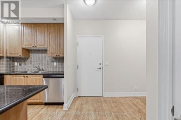 Markham (Unionville) condo for rent - A kitchen with wooden cabinets and a black counter top.